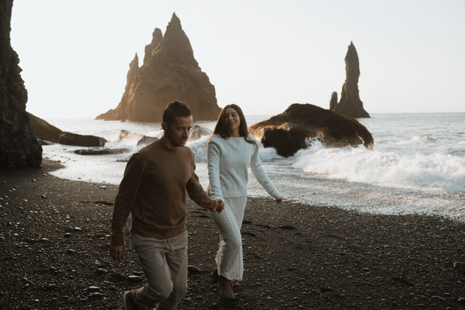 Intimate couple on Reynisfjara beach, surrounded by Icelandic landscape