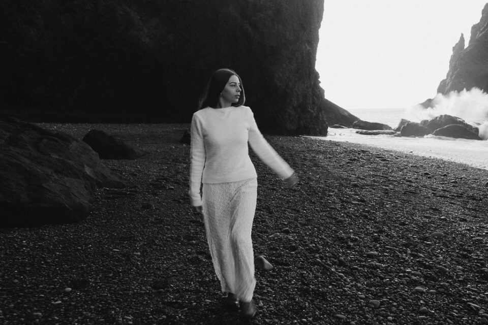 bride to be captured in movement on black sand beach 
