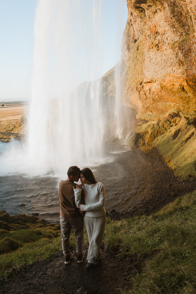 Mesmerizing elopement couple embracing near the base of Seljalandsfoss waterfall, Iceland