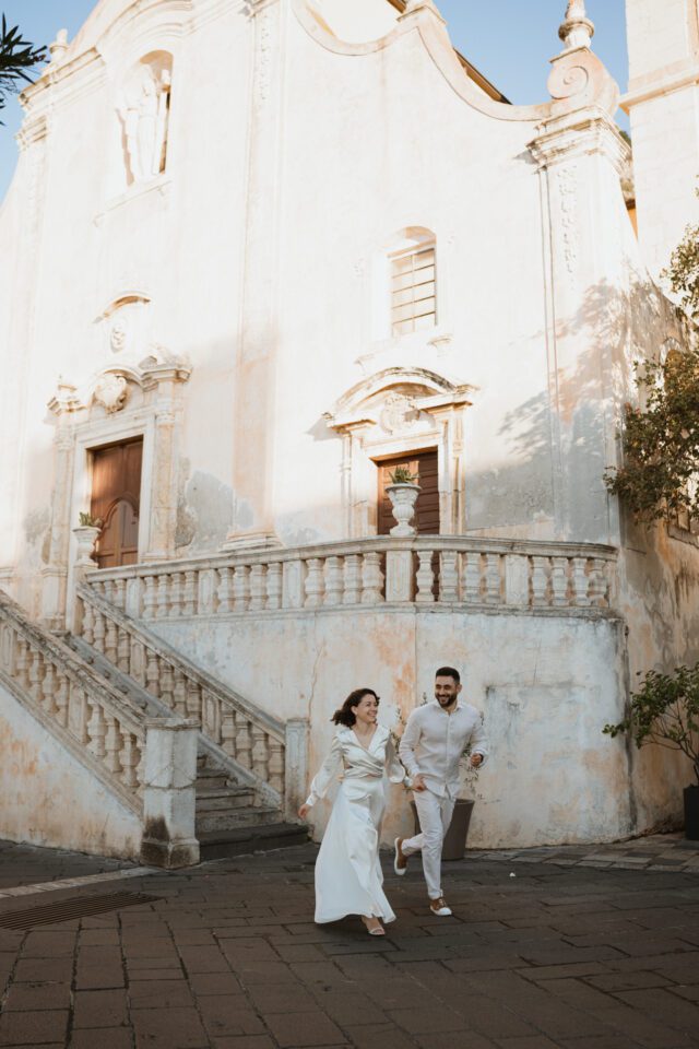 Couple walking through historic streets in Sicily