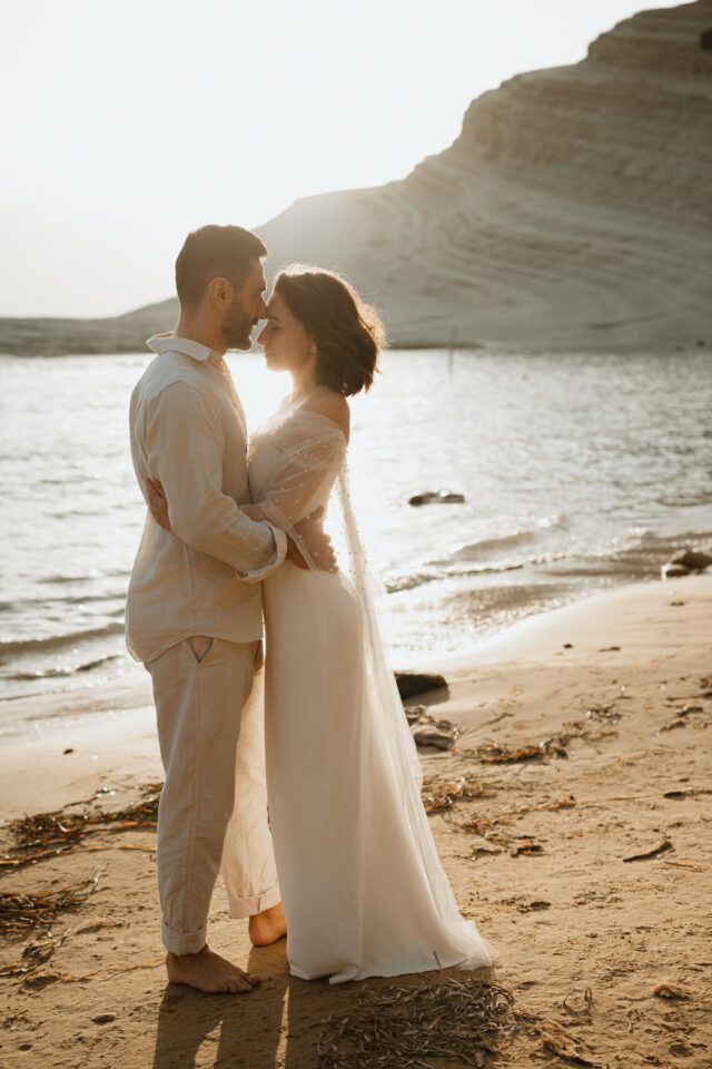 Romantic couple walking barefoot on Sicily beach
