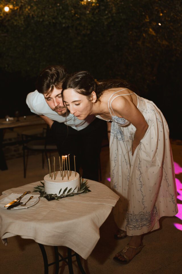 Bride and groom with wedding cake during destination wedding in Greece
