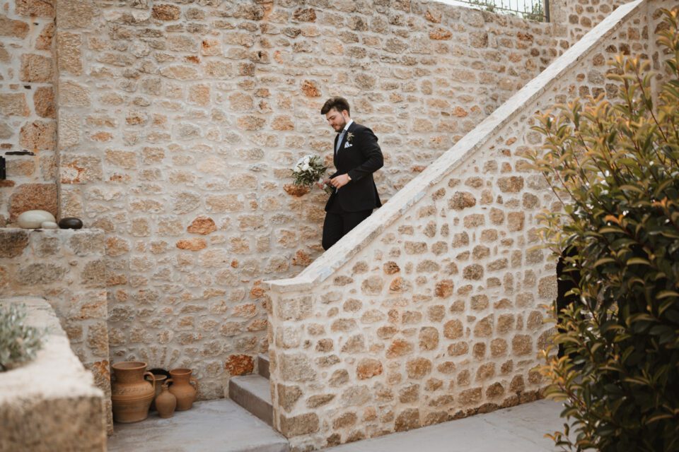 groom walking down stone steps at Alistos Hotel