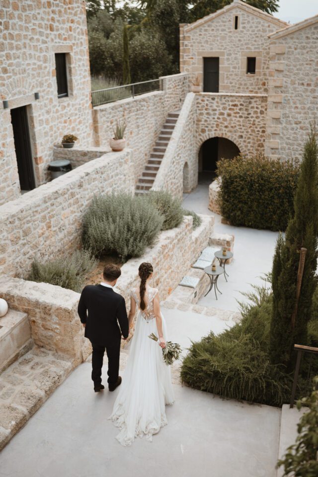 Bride and groom walking through historic Greek venue