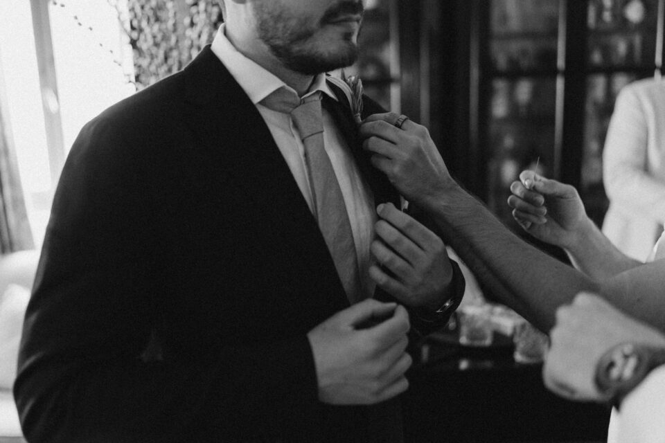 Groom adjusting suit before ceremony in Greece
